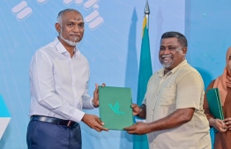 Haanim Mohamed, a leading figure in the sports and fitness industry handing over his registration form to President Muizzu after signing into People's National Congress (PNC). -- Photo: PNC