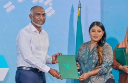 A new member who joined People's National Congress (PNC) handing over her registration form to President Muizzu after signing into the party. -- Photo: PNC