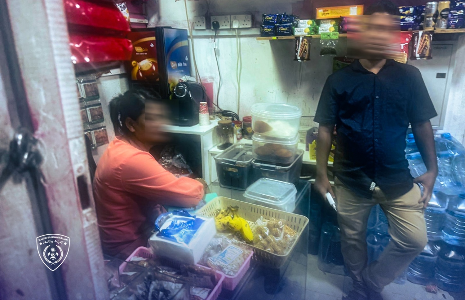 ގަވާއިދާ ހިލާފަށް ވިޔަފާރި ހިންގާ ބިދޭސީން އަތުލައިގަންނަން ހިންގި ރެއިޑް އޮޕަރޭޝަންގައި އިމިގްރޭޝަން އޮފިސަރަކު، ބިދޭސީއަކު ހިންގާ ހަޓެއް ކައިރީގައި މަޑުކޮށްލައިގެން.---ފޮޓޯ: އިމިގްރޭޝަން