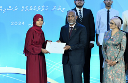 President Dr Mohamed Muizzu presents scholarship awarding letter.-- Photo: Nishan Ali / Mihaaru