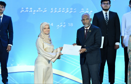 President Dr Mohamed Muizzu presents scholarship awarding letter.-- Photo: Nishan Ali / Mihaaru