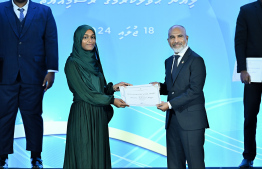 Minister of Education Dr Ismail Shafeeu presents scholarship awarding letter.-- Photo: Nishan Ali / Mihaaru