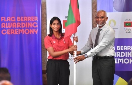 President Dr Mohamed Muizzu entrusting the Maldivian flag to a flag bearer of the Paris 2024 Olympics, national table tennis star, Dheema Ali. -- Photo: President's Office