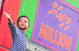 A child waving at MNDF officers during the parade held yesterday by MNDF to commemorate Maldives' Independence Day. -- Photo: Fayaz Moosa / Mihaaru News