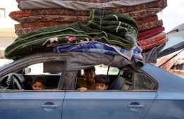 Palestinians use a car to flee the Hamad residential district and its surroundings in Khan Yunis in the southern Gaza Strip after receiving a warning from the Israeli army to evacuate the area on August 11, 2024, amid the ongoing conflict between Israel and the Hamas militant group. -- Photo: Bashar Taleb / AFP