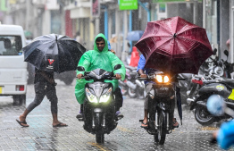 People active on Majeedhee Magu during heavy rain and strong gusts in Male' City. -- Photo: Nishan Ali / Mihaaru News