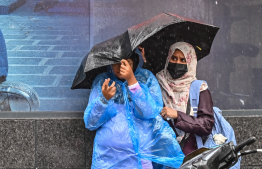 Two women stuck on the road due to heavy rain in Male' City yesterday. -- Photo: Nishan Ali / Mihaaru News