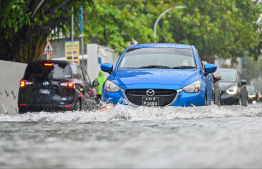 A car travelling through the flash flood in Ameenee Magu caused by heavy rain yesterday. -- Photo: Fayaz Moosa / Mihaaru News