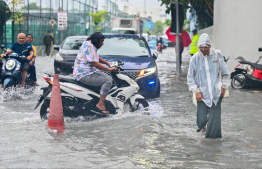 People active on Amenee Magu during heavy rain and strong gusts in Male' City. -- Photo: Fayaz Moosa / Mihaaru News