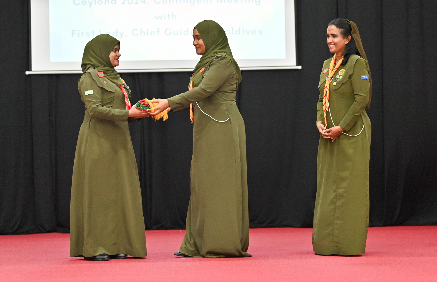 ރޭ ސަލާޙުއްދީން ސްކޫލުގައި ބޭއްވި ހާއްސަ ޖަލްސާގައި ފަސްޓް ލޭޑީ ސާޖިދާ މުހައްމަދު، ކޭމްޕުގައި ބައިވެރިވާ ރާއްޖޭގެ ކޮންޓިންޖެންޓުގެ އިސްވެރިޔާއަށް ގައުމީ ދިދަ ހަވާލުކޮށްދެއްވަނީ-- ފޮޓޯ: ރައީސް އޮފީސް