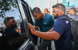 An undocumented immigrant being brought into Immigration custody during yesterday's operations. -- Photo: Fayaz Moosa / Mihaaru News