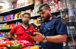 Immigration Controller Shamaan verifying documents of an immigrant working at a local store in the city. -- Photo: Fayaz Moosa / Mihaaru News