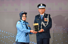 Police Commissioner, Ali Shujau awarding the plaque of memorandum to a police officer in recognition of her service in the line of duty for over 25 years. -- Photo: Nishan Ali / Mihaaru News