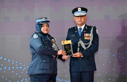 Police Commissioner, Ali Shujau awarding the plaque of memorandum to a police officer in recognition of her service in the line of duty for over 25 years. -- Photo: Nishan Ali / Mihaaru News