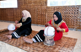 Two women engaged in embroidery works at the 'Traditional Dhivehi Land' in Maafushi Prison. -- Photo: President's Office