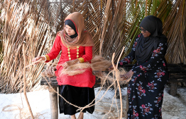 Two women engaged in coir rope weaving at the 'Traditional Dhivehi Land' in Maafushi Prison. -- Photo: President's Office