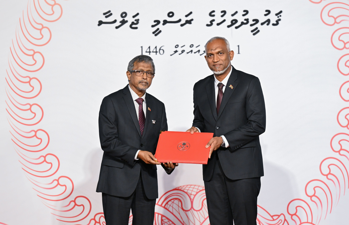 ސަރުކާރުން މި އަހަރު ޝަރަފުވެރިކަމުގެ އިނާމު ދިން، އެތެރެހަށީގެ ހާއްސަ ޑޮކްޓަރު އަބްދުލް އަޒީޒު ޔޫސުފް (ޑރ. އަޒީ) އާ ރައީސް މުއިއްޒު ހަދާނީ ލިޔުން ހަވާލު ކުރައްވަނީ.---ފޮޓޯ: ރައީސް އޮފީސް