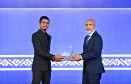 Minister of Education Dr Ismail Shafeeu presenting an award to a student at the High Achievers Award Ceremony 2022-2023 held today. -- Photo: Nishan Ali / Mihaaru News