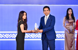 Minister of Economic Development and Trade Mohamed Saeed presenting an award to a student at the High Achievers Award Ceremony 2022-2023 today. -- Photo: Nishan Ali / Mihaaru News