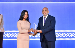 Minister of Housing, Land and Urban Development Ali Haidar Ahmed presenting an award to a student at the High Achievers Award Ceremony 2022-2023 today. -- Photo: Nishan Ali / Mihaaru News