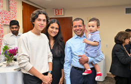 Permanent Representative of the Maldives to the United Nations Dr Ali Naseer Mohamed holding a baby and posing for a photo with the family during the ceremony held in the Permanent Mission of the Republic of Maldives for the President's meeting with the Maldivian community residing in America. -- Photo: President's Office