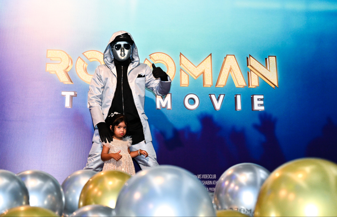 ކުޑަކުދިންގެ ފިލްމް "ރޮބޯމޭން: ދަ މޫވީ"ގެ ރެޑްކާޕެޓް އިވެންޓުގައި، ރޮބޯމޭންއާ އެކު ކުޑަކުއްޖަކު ފޮޓޯއަކަށް ހުއްޓިގެން.-- ފޮޓޯ: ފަޔާޒް މޫސާ | މިހާރު