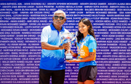 Ayana Areef being awarded the championship trophy by Swimming Association President Mohamed AbduSattar.