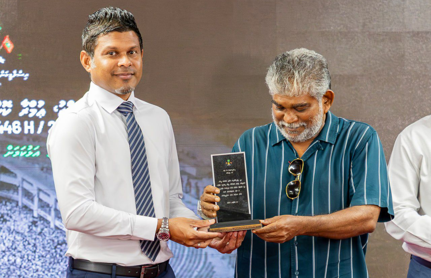 "ހައްޖު އުމްރާ ކޮންފަރަންސް"ގައި ދިގު މައްދަތަށް ހިދުމަތް ކުރެއްވި އަލްމަރުހޫމް ދިއްދޫ އިބްރާހިމް ކަލޭފާނު އަށް ނައިބް ރައީސް ހުސެއިން މުހައްމަދު ލަތީފް އެވޯޑު ދެއްވަނީ.-- ފޮޓޯ: އިސްލާމިކް މިނިސްޓްރީ