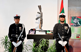 Officers stand next to the weapon used by Shaheed Hussain Adam during the terrorist attack on November 3, 1988 on display at the exhibition. The martyred corporal was guarding the main gate of the military headquarters during the onset of the attack -- Photo: Nishan Ali