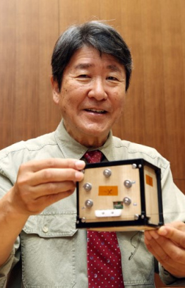 (FILES) This file photo taken on May 28, 2024 shows Takao Doi, an astronaut and special professor at Kyoto University, holding the world's first wooden satellite, named LignoSat, during a press conference at the university's campus in Kyoto. The world's first wooden satellite has blasted off on a SpaceX rocket, its Japanese developers said on November 5, 2024, part of an resupply mission to the International Space Station. (Photo by JIJI PRESS / AFP) /