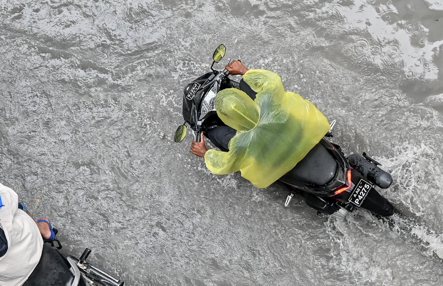 ބޯކޮށް ވެހުނު ވާރޭގައި މަގެއްގައި ފެންބޮޑުވެފައި އޮއްވައި މީހަކު ސައިކަލެއްގައި ދުއްވާފައި ދަނީ -- ފޮޓޯ: ނިޝާން އަލީ | މިހާރު