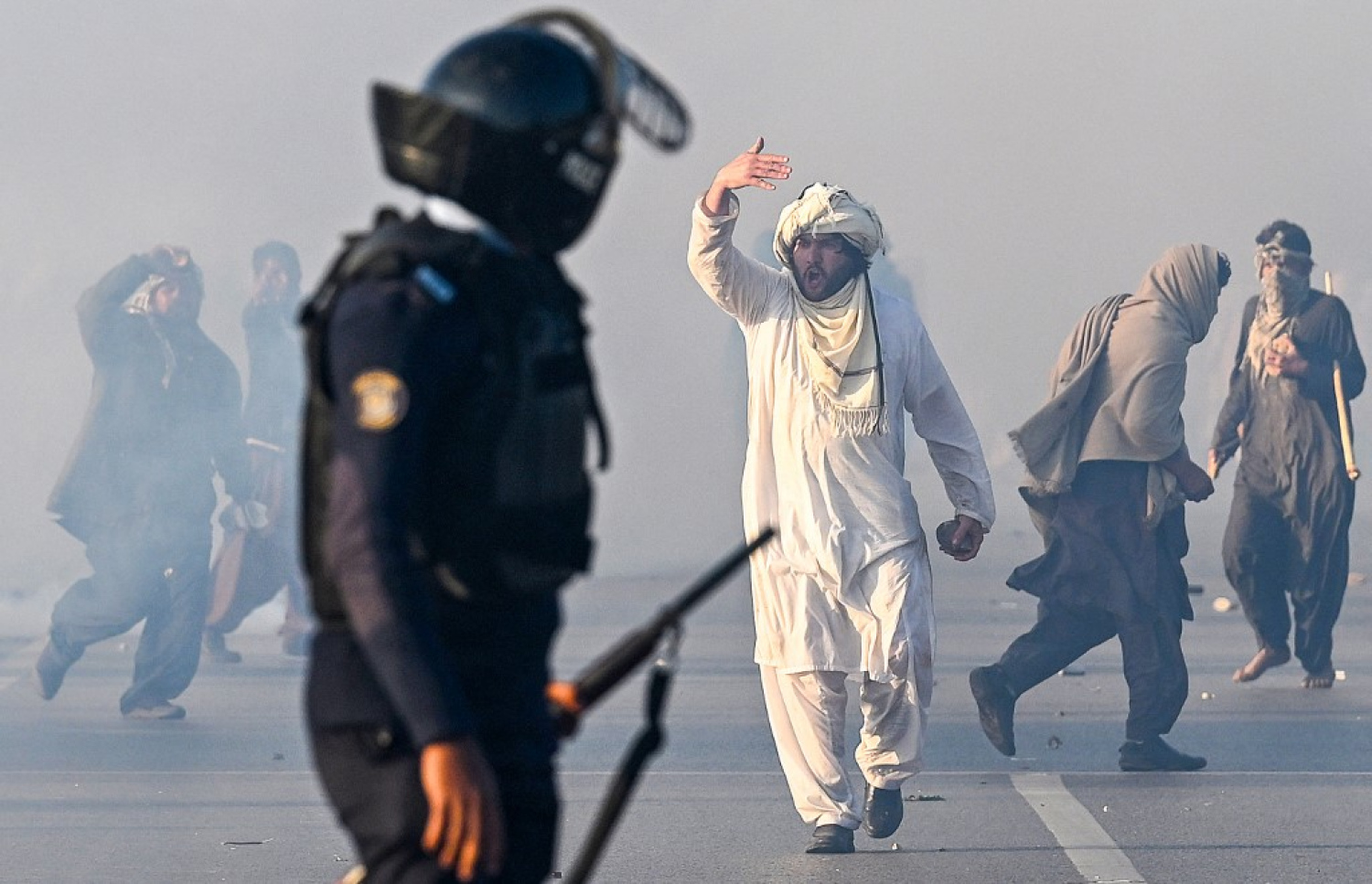 ޕާކިސްތާނުގެ ވެރިރަށް އިސްލާމްއާބާދުގައި ކުރީގެ ބޮޑުވަޒީރު އިމްރާން ހާންގެ ސަޕޯޓަރަކު މުޒާހަރާ ތެރޭ ފުލުހަކާ ވާހަކަ ދައްކަނީ. -- ފޮޓޯ: އޭއެފްޕީ