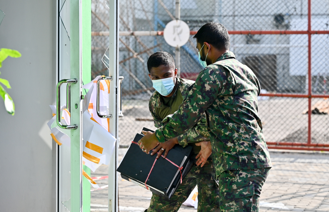 މ. ގްރީން ބިލްޑިންގައި ހިންގާ އޮފީހަކުން ސަލާމަތްކުރެވެން ހުރި ބައެއް ސާމާނު ސިފައިން އެތަނުން ނެރެނީ.-- ފޮޓޯ: ނިޝާން އަލީ | މިހާރު