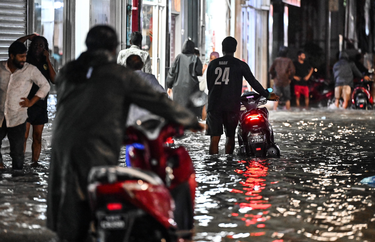 ޖެނުއަރީ 3، 2025: މާލޭގެ މަގުމަތީގައި މާ ބޮޑަށް ފެންބޮޑުވެ ސައިކަލް ނުދުއްވޭ ވަރު ވުމުން ބަޔަކު ސައިކަލުތައް ދާމަފައި ފެންގަނޑުގެ ތެރެއިން ގެންދަނީ.-- ފޮޓޯ: ނިޝާން އަލީ | މިހާރު