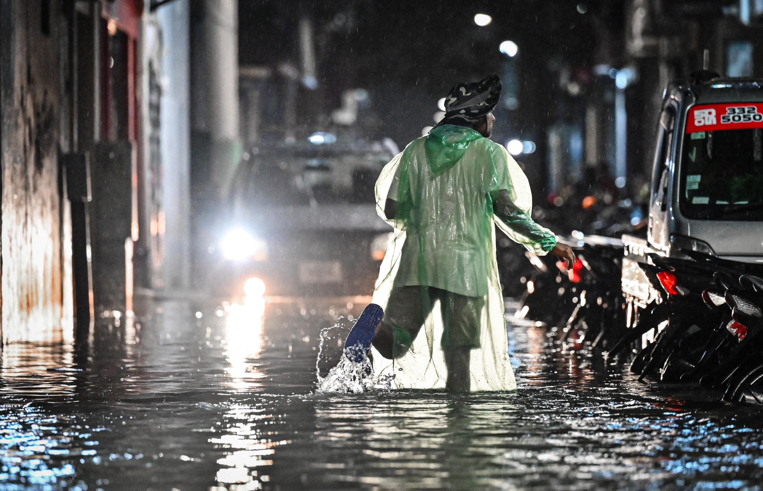 ޖެނުއަރީ 3، 2025: ބޯކޮށް ވާރޭވެހި ފެންބޮޑުވެފައި އޮތް މާލޭގެ މަގަކުން މީހަކު ހިނގާފައި ދަނީ.-- ފޮޓޯ: ނިޝާން އަލީ | މިހާރު