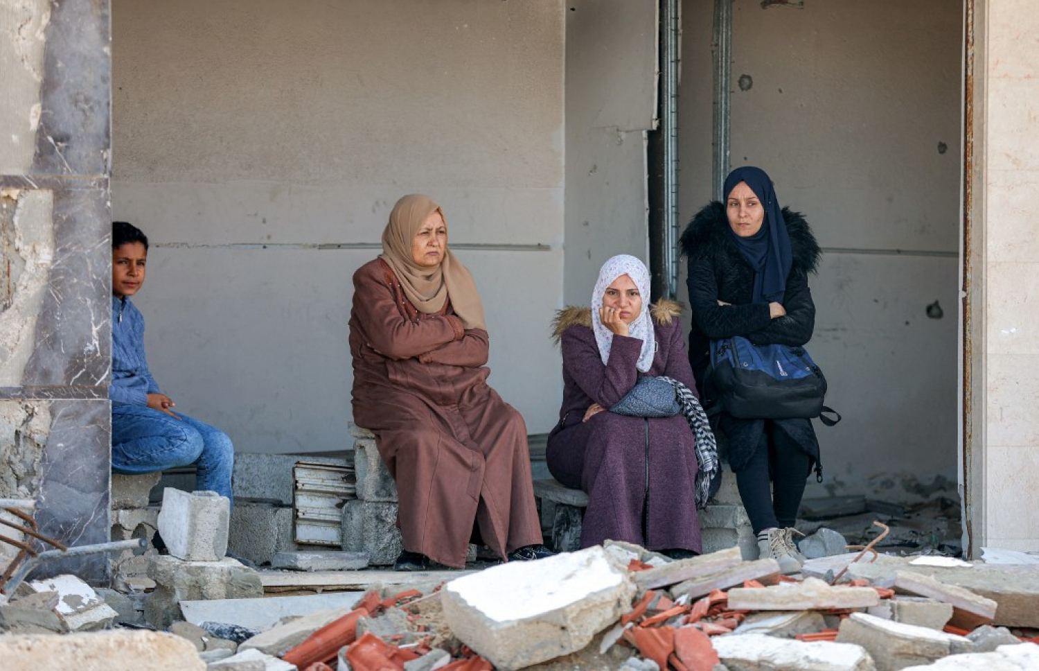 ފަލަސްތީނުގެ ޣައްޒާގައި ބަޔަކު އިމާރާތެއްގެ ހަލާކުވެފައިވާ ގާތަކެއްގެ މަތީ އިށީނދެލައިގެން. -- ފޮޓޯ: އޭއެފްޕީ