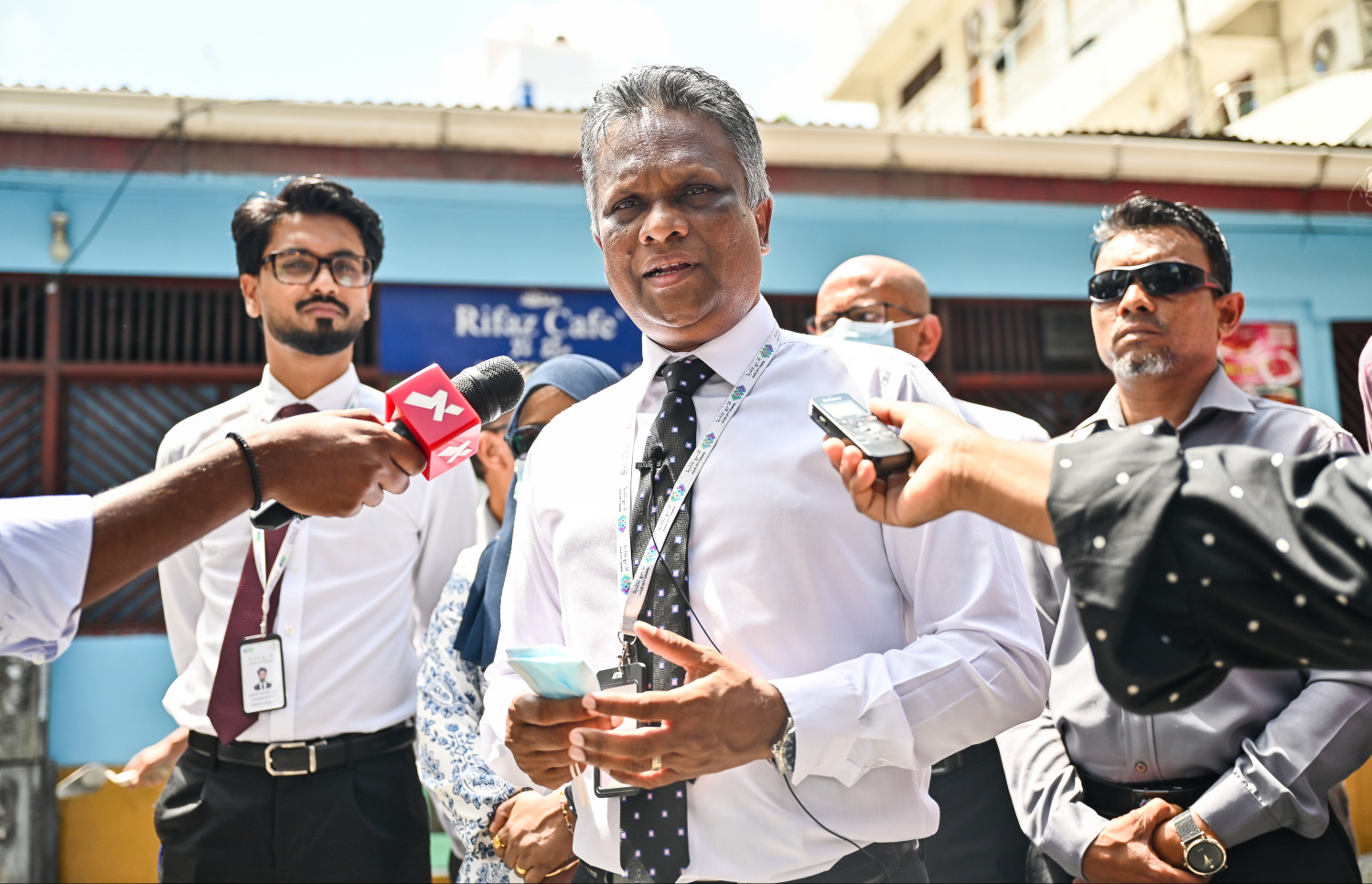 މަގުމަތީ ހުރި ޖަންކްޝަނަކަށް ނަޖިސް އެޅޭ ގޮތް ހެދި ރިފާޒް ކެފޭ ކައިރީ ހުރެ މާލޭގެ މޭޔަރު އާދަމް އާޒިމް ވާހަކަ ދައްކަވަނީ-- ފޮޓޯ: ފަޔާޒް މޫސާ / މިހާރު