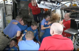 This screengrab made from a NASA livestream shows the SpaceX Dragon Crew-10 members, including NASA astronauts Anne McClain and Nichole Ayers, JAXA (Japan Aerospace Exploration Agency) astronaut Takuya Onishi, and Roscosmos cosmonaut Kirill Peskov, greeting International Space Station crew members including NASA astronauts Butch Wilmore (L) and Suni Williams (3R) on March 16, 2025. The SpaceX Dragon Spacecraft carrying the four Crew-10 members docked to the International Space Station on March 16 at 12:04 a.m. EDT. Their arrival at the  the ISS will enable the long-overdue departure from the ISS of NASA duo Butch Wilmore and Suni Williams. The two former US Navy pilots have been stuck aboard the orbital lab since June after the Boeing Starliner spacecraft they were testing on its maiden crewed voyage suffered propulsion issues and was deemed unfit to fly them back to Earth. (Photo by NASA / AFP) / 