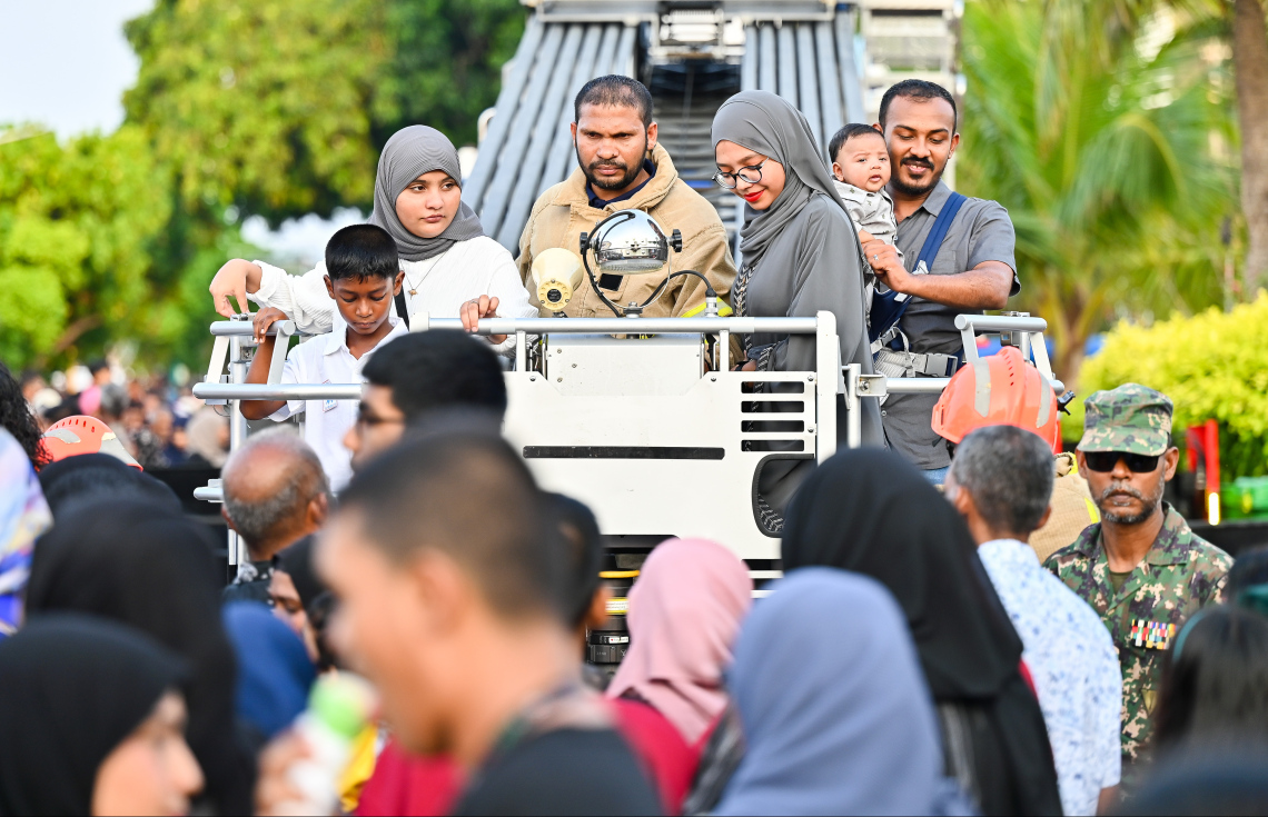 އީދު ހަވީރުގައި ސިފައިން އަލިފާން ނިއްވުމަށް ބޭނުންކުރާ ބޮޑު ވެހިކަލަށް ބަޔަކު ކުޑަކުދިން ގޮވައިގެން އަރަނީ -- ފޮޓޯ: ފަޔާޒު މޫސާ | މިހާރު