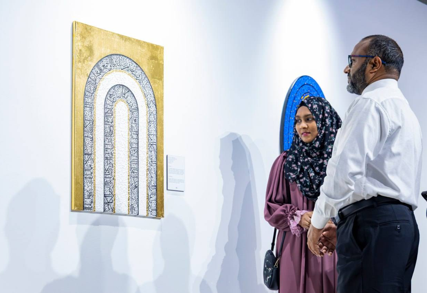 އިސްލާމިކް މިނިސްޓަރު ޑރ. ޝަހީމް، އާޓް އެގްޒިބިޝަނަށް ނަސްމާ ހުށަހެޅި އާޓު ޕީސް ބައްލަވާލައްވާއިރު ކައިރީގައި ނަސްމާ މަޑުކޮށްލައިގެން.