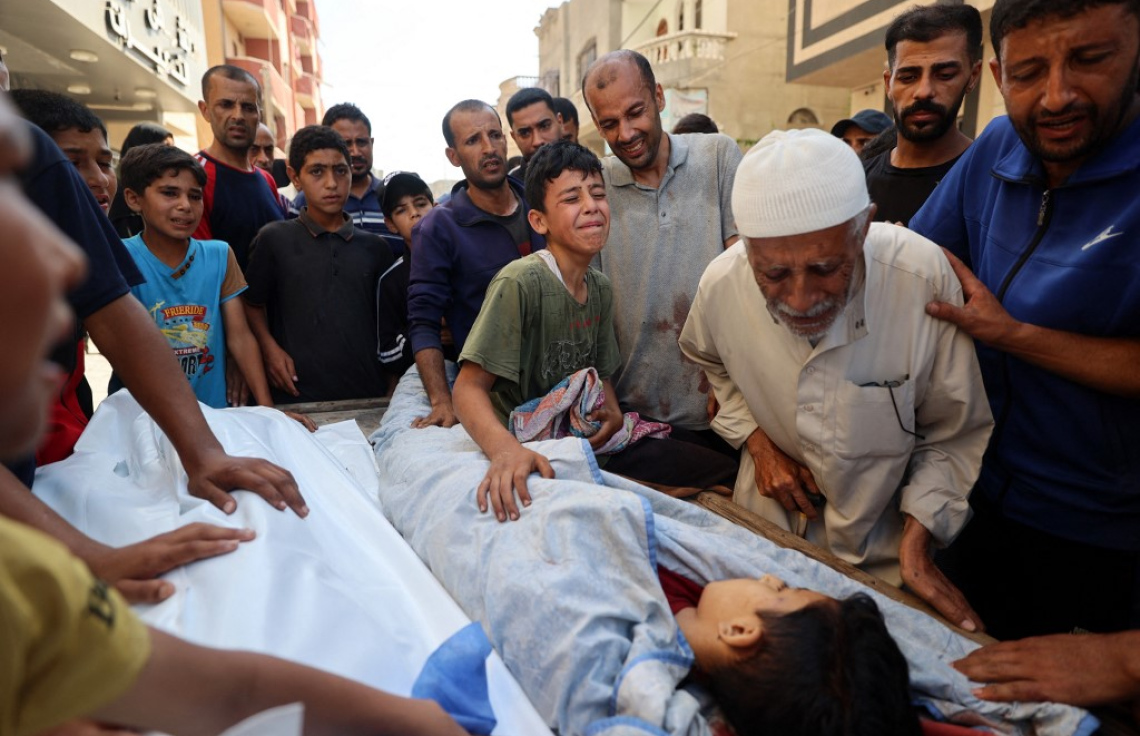 ޣައްޒާގައި ޝަހީދުކޮށްލި ކުޑަކުއްޖެއްގެ ހަށިގަނޑު ކައިރީ އާއިލާގެ މީހުން ހިތާމާގައި. -- ފޮޓޯ: އޭއެފްޕީ