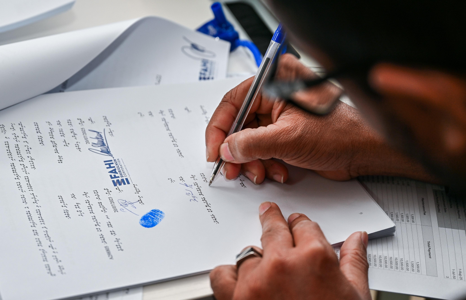 ފްލެޓް އެއްބަސްވުމެއްގައި މީހަކު ސޮއިކުރަނީ.-- ފޮޓޯ: ފަޔާޒު މޫސާ | މިހާރު