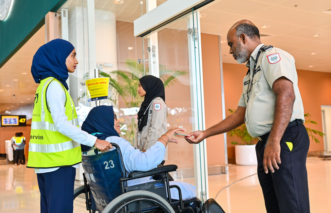 ވެލާނާ އިންޓަނޭޝަނަލް އެއާޕޯޓުގެ އާ ޓާމިނަލް ހުޅުވުމުގެ ކުރިން ކުރިއަށް ގެންދާ ފުލް ޓްރަޔަލްގެ ބައިވެރިޔަކު، ފުރާ މީހުންގެ ގޭޓުން ވަަނުމުގެ ކުރިން އޭވިއޭޝަން ސެކިއުރިޓީން ޕާސްޕޯޓް ޗެކް ކުރަނީ.--- ފޮޓޯ: ފަޔާޒު މޫސާ | މިހާރު