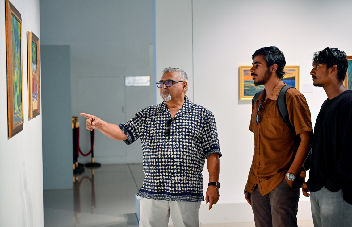 ހުނަރުވެރި ކުރެހުންތެރިޔާ މަނާގާ އަބްދުﷲ ފާއިޒުގެ ކުރެހުމުގެ މައުރަޒަށް ޒިޔާރަތްކުރި ދެ ޒުވާނަކަށް އޭނާ ބައެއް ކުރެހުންތަކުގެ މައުލޫމާތު ދެއްވަނީ: "ޖާނީ ބައި އަބްދުﷲ ފާއިޒު" ގެ ނަން ދީފައިވާ މި ކުރެހުމުގެ މައުރަޒަށް ބޮޑު ތަރުހީބެއް އަންނަނީ ލިބެމުން.---ފޮޓޯ: ނިޝާން އަލީ| މިހާރު