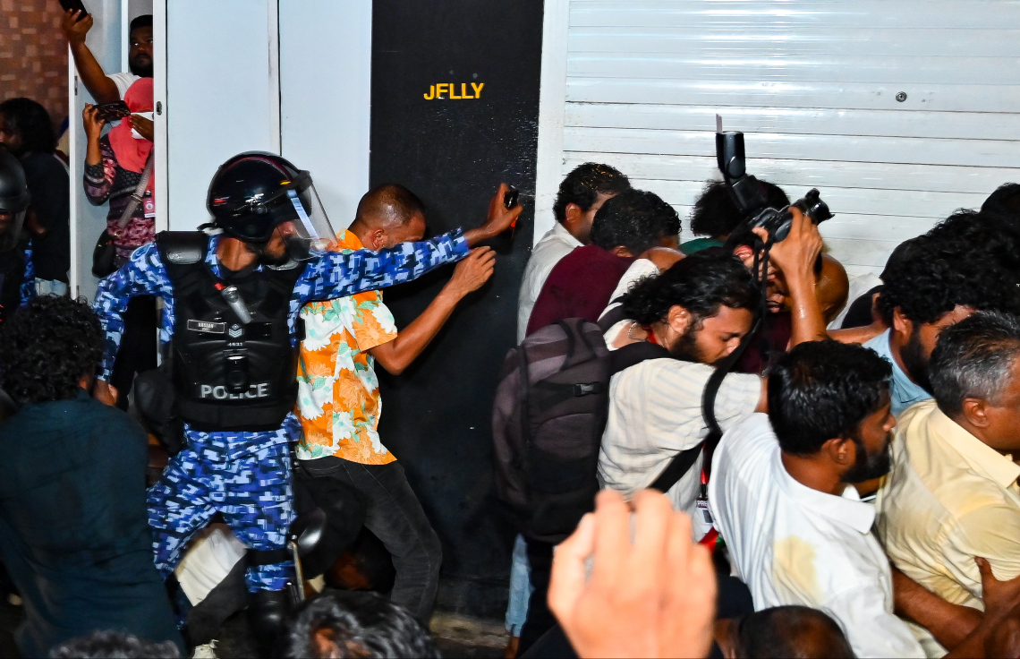 އިދިކޮޅު އެމްޑީޕީގެ ބޮޑު އެއްވުމުގެ ބައިވެރިން ފުލުހުންގެ އެންގުމާ ހިލާފަށް މަޖީދީ މަގުން ދާން މަސައްކަތް ކުރުމުން، އެ މީހުން ފަހަތަށް ޖައްސަން ފުލުހުން ޕެޕާސްޕްރޭ ޖަހަނީ.---ފޮޓޯ: ފަޔާޒު މޫސާ| މިހާރު