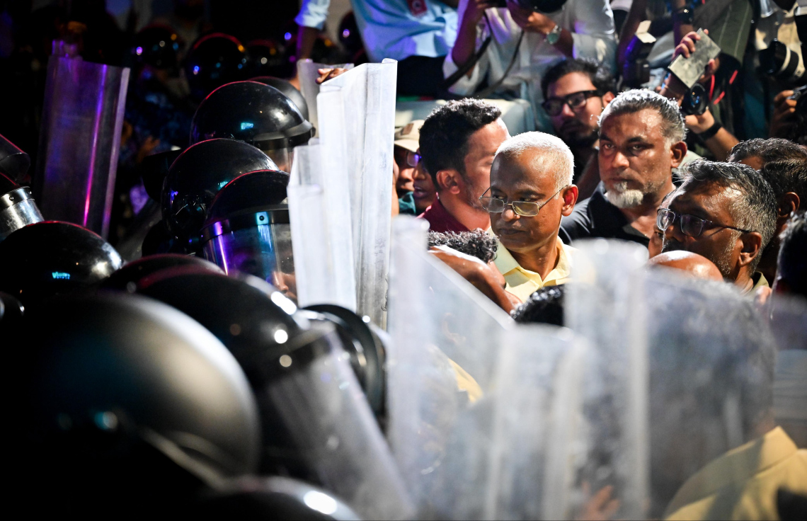 މަޖީދީ މަގުން އެމްޑީޕީގެ އެއްވުމުގެ ބައިވެރިން ކުރިއަށް ދާން ފުރުސަތު ނުލިބުމުން ކުރީގެ ރައީސް އިބްރާހިމް މުހައްމަދު ސޯލިހު ފުލުހުންގެ ޝީލްޑުތައް ކައިރީގައި މަޑުކޮށްލައްވައިގެން: ފުލުހުން ބުނެފައި ވަނީ މި އެއްވުމަށް ހުއްދަ ދިނީ އަމީނީ މަގާއި ބޮޑުތަކުރުފާނު މަގުން ކުރިއަށް ދާން ކަމަށް.---ފޮޓޯ: ނިޝާން އަލީ| މިހާރު