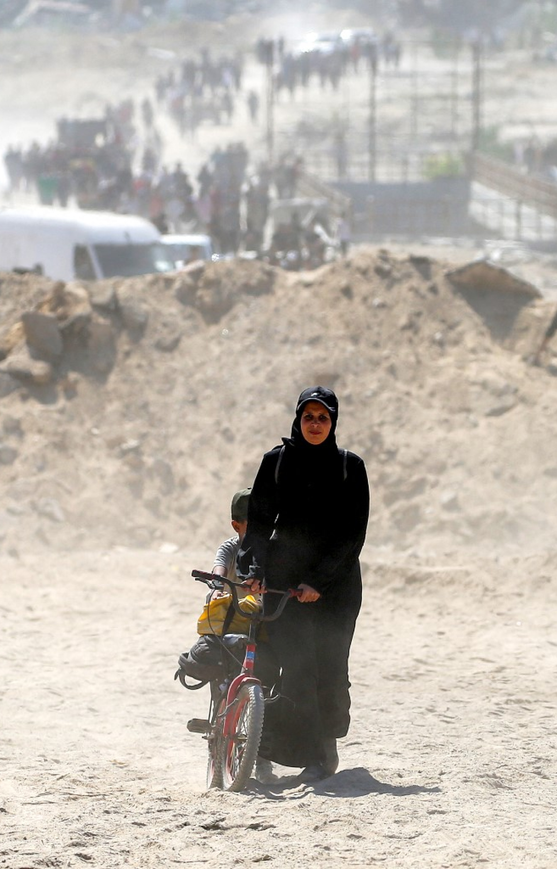 ޣައްޒާގައި ހަމަލާތައް މެދުކަނޑާލުމުން ފަލަސްތީނު އަންހެނަކު ބައިސްކަލަކަށް ކުއްޖަކާއި ބައެއް މުދާ އަރުވައިގެން އަމިއްލަ ގެދޮރަށް ދާން ހިނގާފައި އަންނަނީ. -- ފޮޓޯ: އޭއެފްޕީ