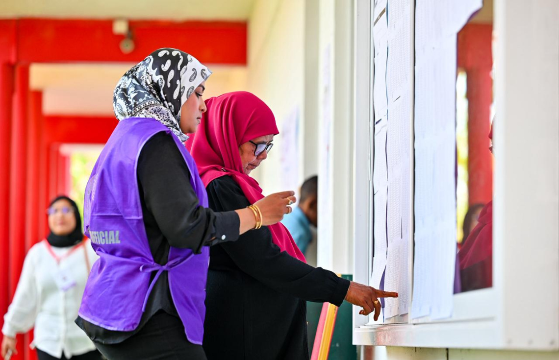 ފޭދޫ ސްކޫލްގައި ބަހައްޓާފައިވާ ފޮއްޓަށް ވޯޓުލާން ދިޔަ މީހެއްގެ ނަން ޗެކް ކުރަނީ.---ފޮޓޯ: ނިޝާން އަލީ | މިހާރު