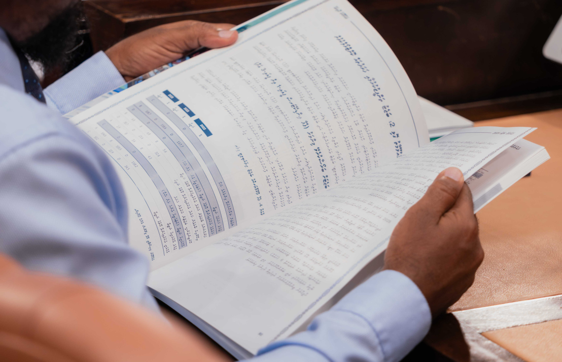 މަޖިލީހުގެ ތަޅުމުގައި މެންބަރަކު ބަޖެޓް ފޮތް ބަލަނީ -- ފޮޓޯ: މަޖިލީސް