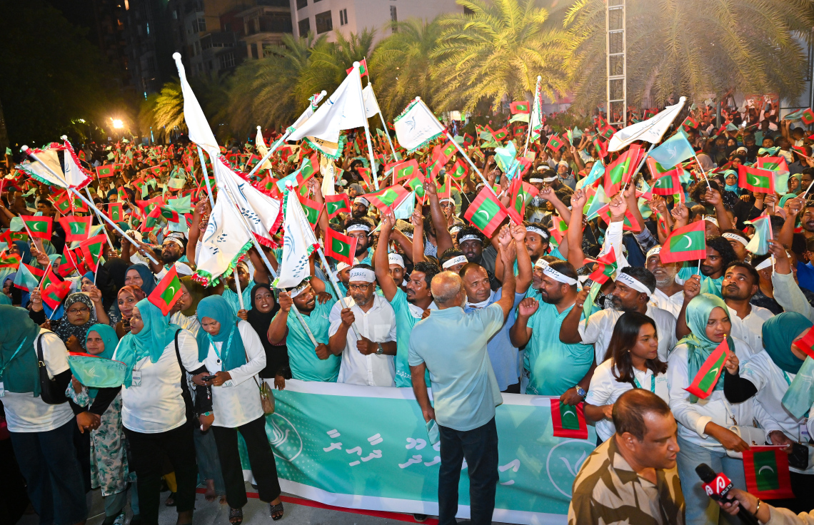 ސަރުކާރު ހިންގާ ޕާޓީ، ޕީއެންސީން މާލޭގެ އާޓިފިޝަލް ބީޗު ސަރަހައްދުގައި ބޭއްވި ބޮޑު ޖަލްސާގައި ބައިވެރިވި ގިނަ އަދަދެއްގެ ބަޔަކު ގައުމީ ދިދަ އާއި އެ ޕާޓީގެ ދިދަ ހިފައިގެން ތިބެ، ރައީސް މުއިއްޒަށް އޮތް ތާއީދު ހާމަކުރަނީ.--- ފޮޓޯ: ފަޔާޒު މޫސާ | މިހާރު